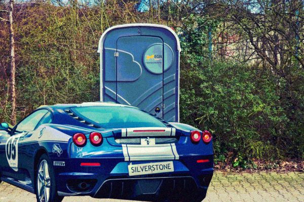 Ein Sportwagen vor einer Toilette