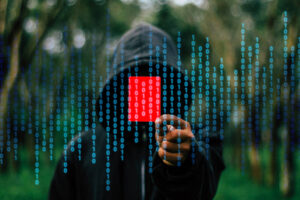 ein Mann, der einen Hacker darstellen soll, hält eine rote Karte hoch. Symbolisch laufen Zahlen durchs Bild.